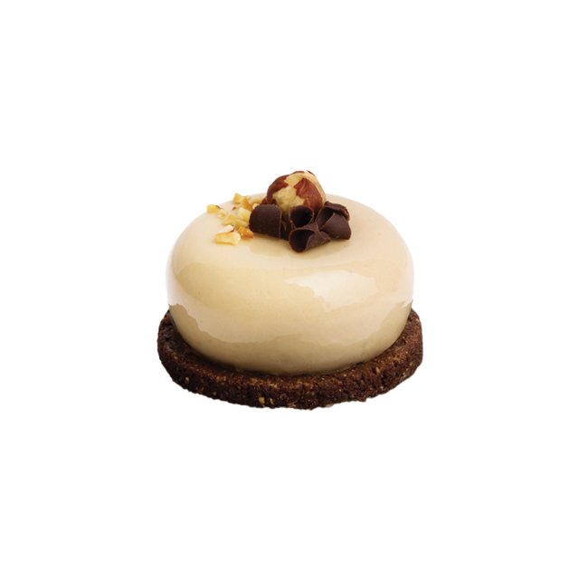 Okrugla mini torta sa sjajnom karamel glazurom na čokoladnoj keks podlozi, sa mljevenim orasima i cijelim lješnikom