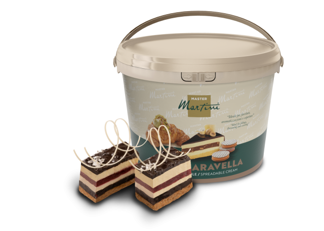 Velika kanta namaza Master Martini "Aravella" pored dvije kriške slojevite torte sa čokoladnim strugotinama.